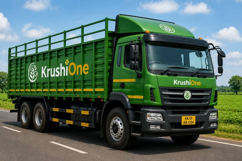 A green goods truck on a road beside farmland